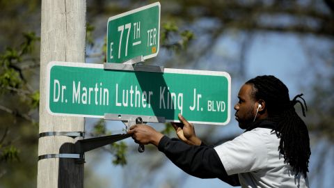 A worker installs a Dr. Martin Luther King Jr. Blvd. sign in Kansas City in April, 2019.