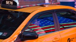 The American flag is reflected on a taxi cab in Times Square on Memorial Day, May 30, 2016 in New York. / AFP / Bryan R. Smith        (Photo credit should read BRYAN R. SMITH/AFP via Getty Images)