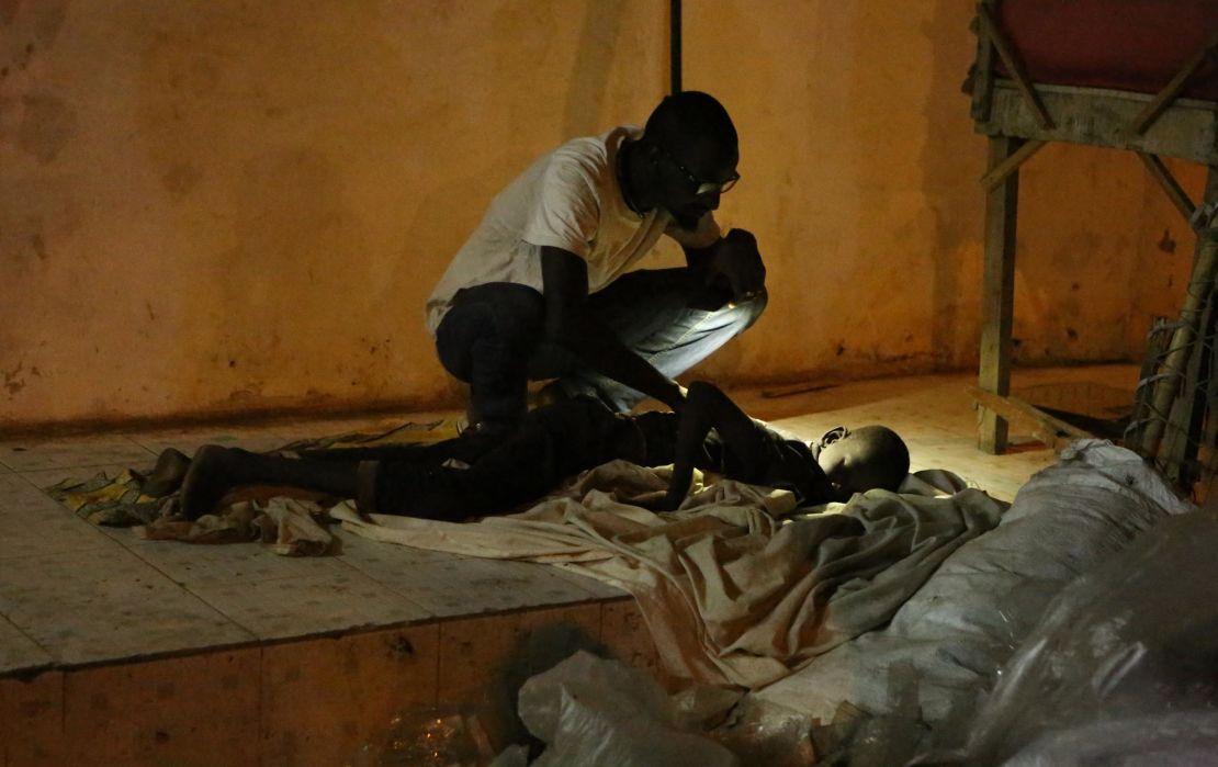 A member of Kouyate's team checking on a boy sleeping in the street.