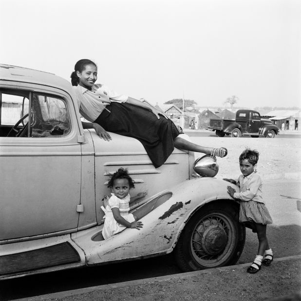 A woman poses on a car in Senegal's streets in 1958.