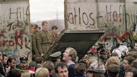 West Berliners crowded in front of the Berlin Wall on November 11 1989, watching East German border guards demolishing a section of the barrier.