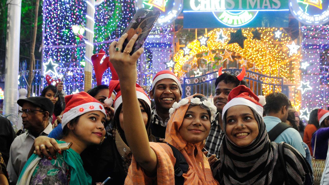 A group of young people takes a selfie during Christmas Eve celebrations  on Park Street in Kolkata.