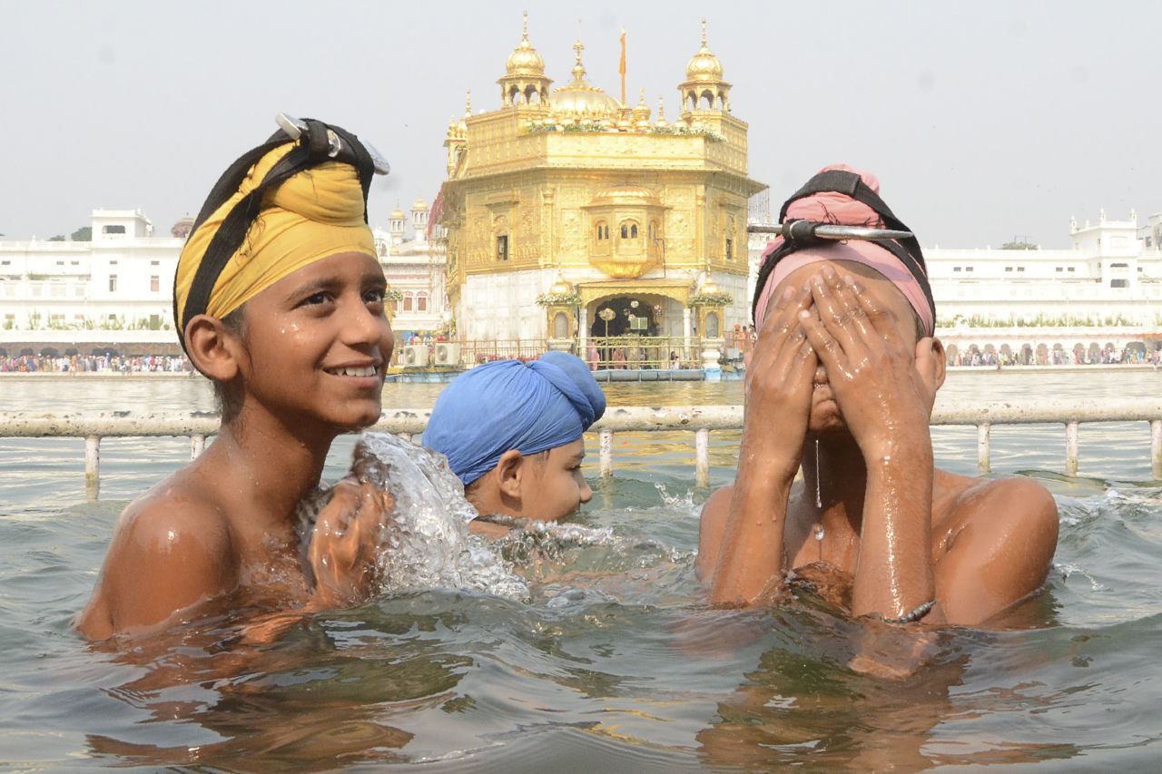 Sikh devotees take a dip in the holy sarovar (water tank), at the Golden Temple in Amritsar, India. 