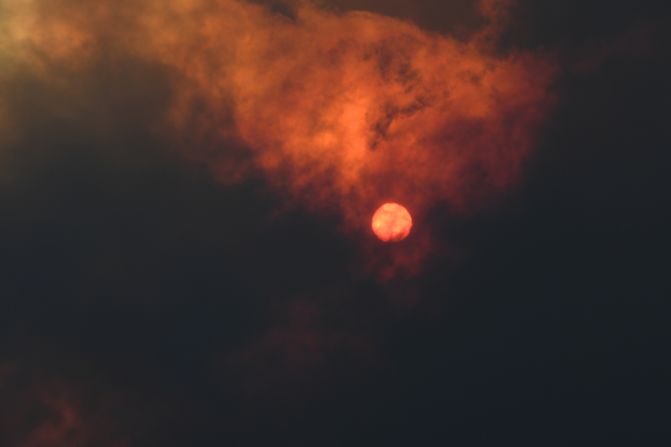 The sun is seen through heavy smoke as a bushfire burns in Woodford.