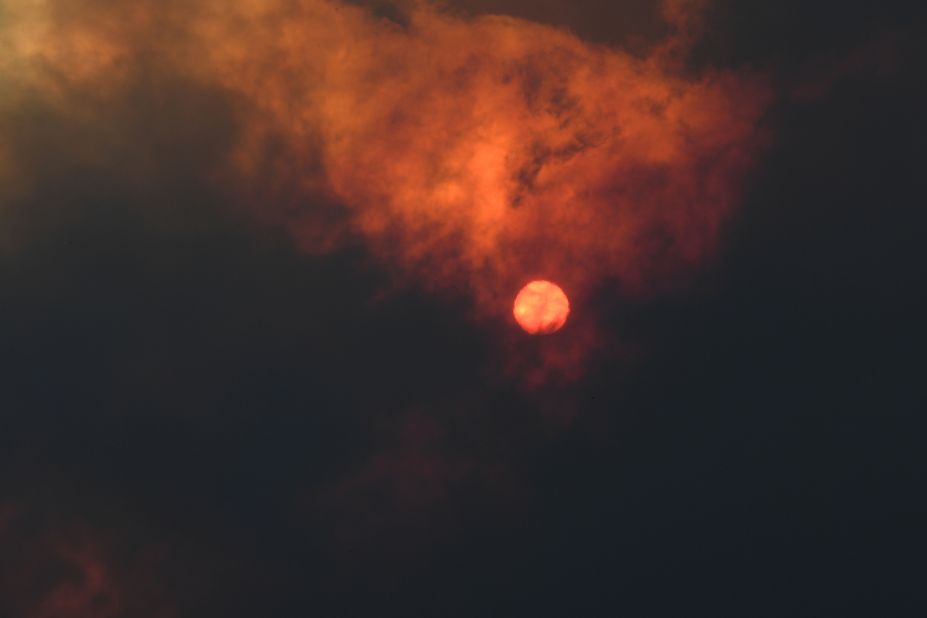 The sun is seen through heavy smoke as a bushfire burns in Woodford.