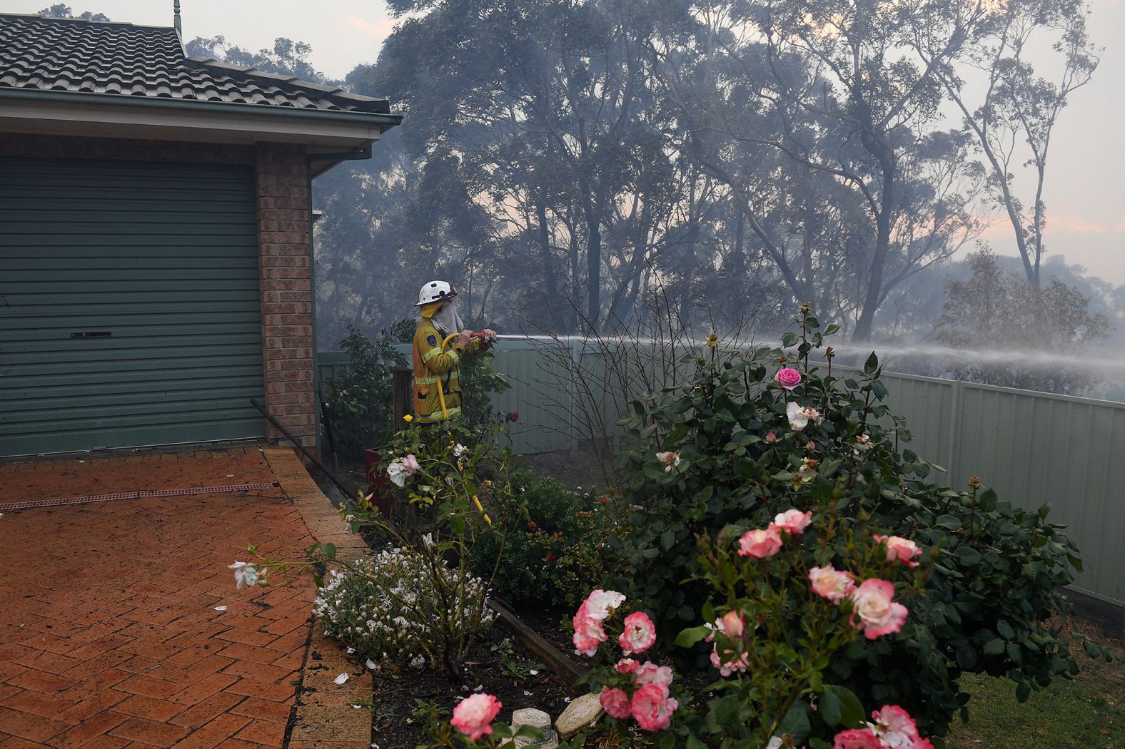 Firefighters hose down an area in Woodford.