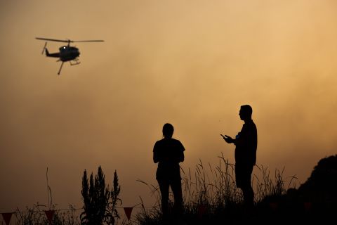 Forster residents watch as a water-bombing helicopter flies over a bushfire on November 7.