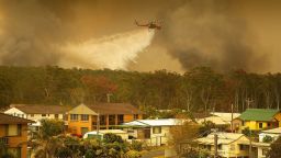 Mandatory Credit: Photo by SHANE CHALKER/EPA-EFE/Shutterstock (10469276j)A water bombing helicopter drops water on a bushfires in Harrington, New South Wales, Australia, 08 November 2019. Hot, windy conditions have seen bushfires burn out of control across parts of New South Wales, with 15 emergency warnings currently in effect in the state.Bushfires burn in New South Wales, Harrington, Australia - 08 Nov 2019
