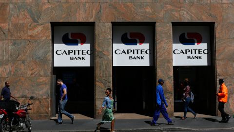 Pedestrians walk past a branch of Capitec Bank in Cape Town.