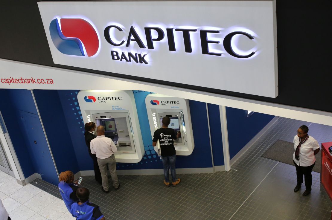 Customers draw money from an ATM outside a branch of Capitec Bank in Johannesburg.