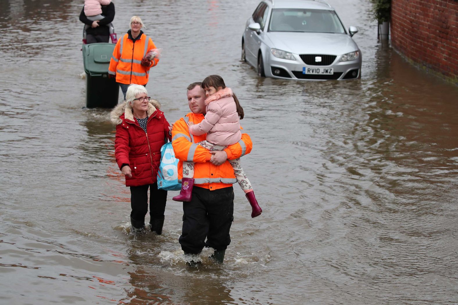 Andrew Hall carries his 6-year-old daughter Lillie-Mai through floodwater in Doncaster.