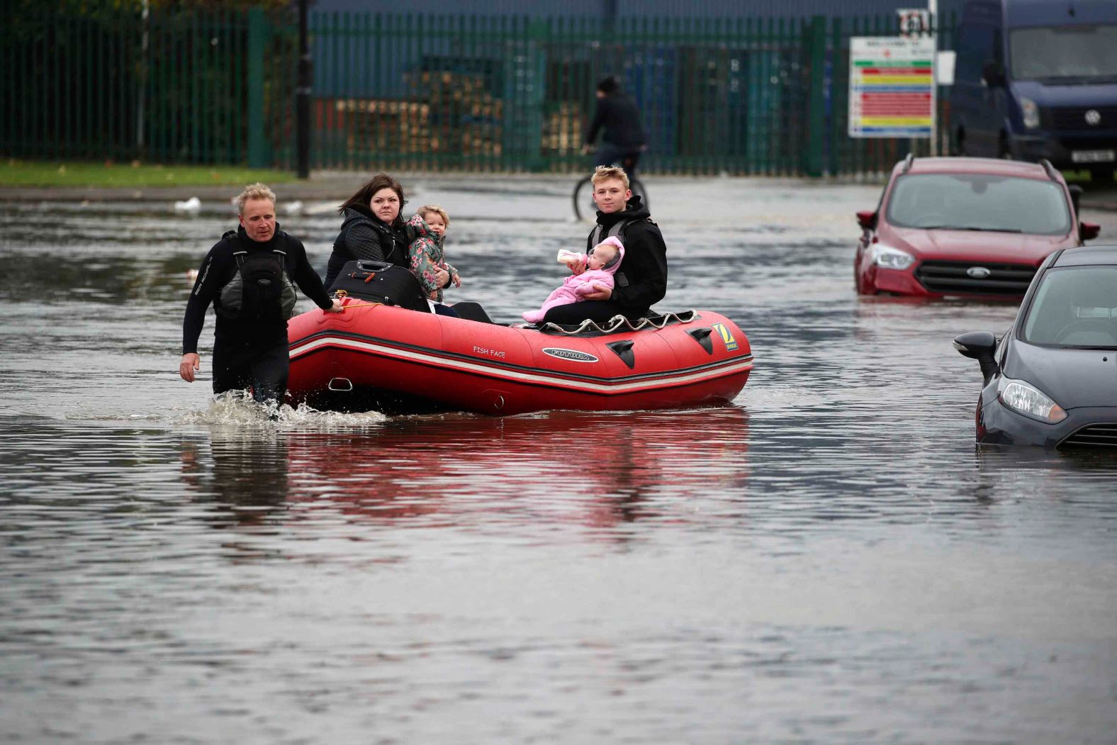 A family is pulled through the floodwater in an inflatable boat in Doncaster on Friday.