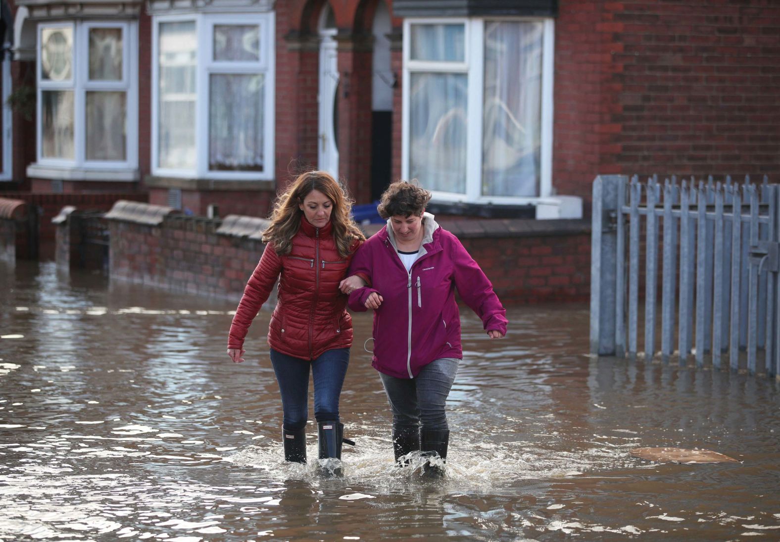 People walk through floodwater on a residential street in Doncaster.