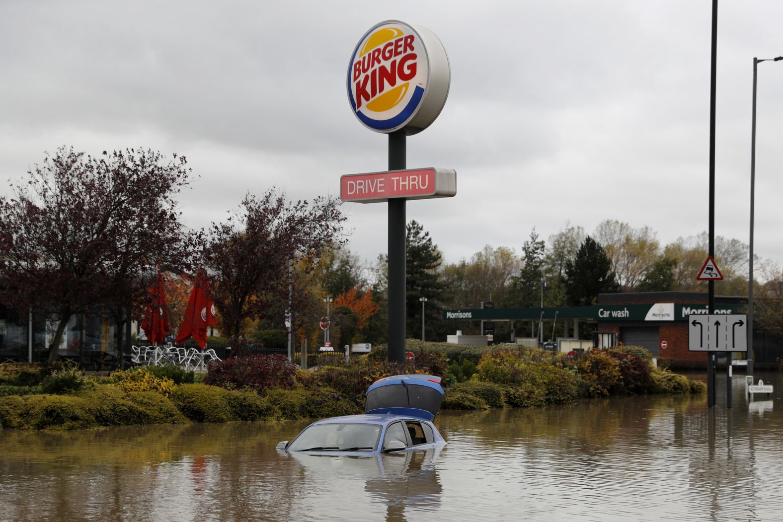 An abandoned car stands in floodwaters outside a Burger King restaurant in Rotherham.