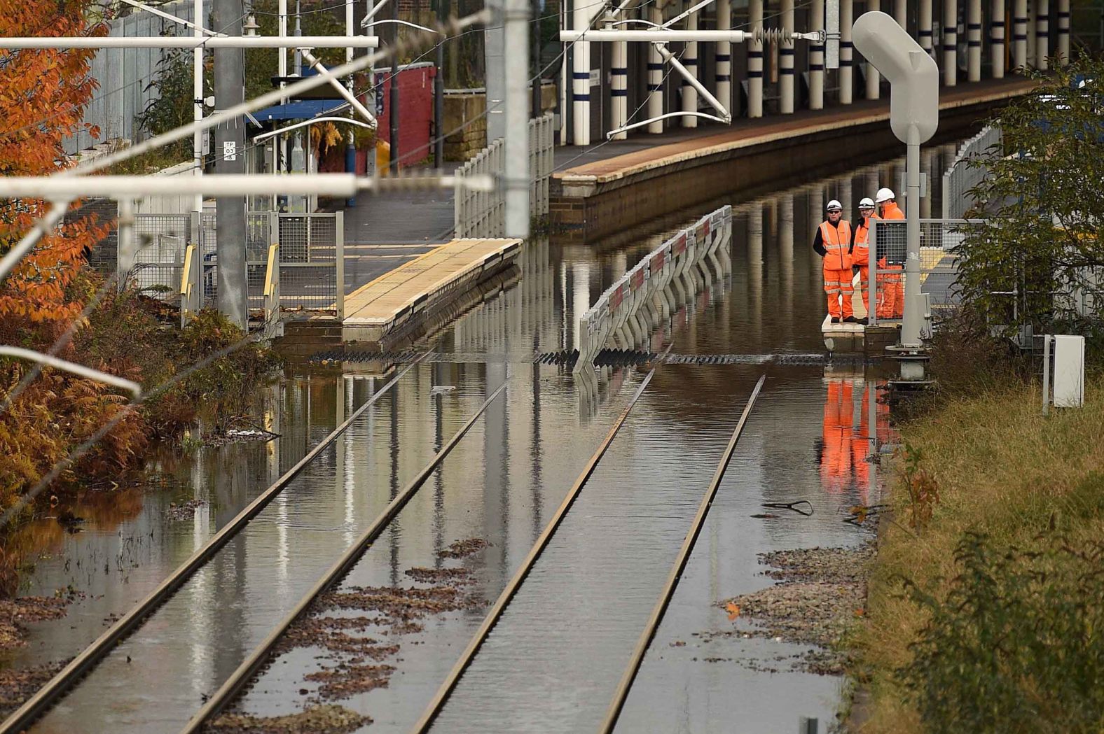 Workers inspect flooded rail tracks at the Rotherham Central train station.