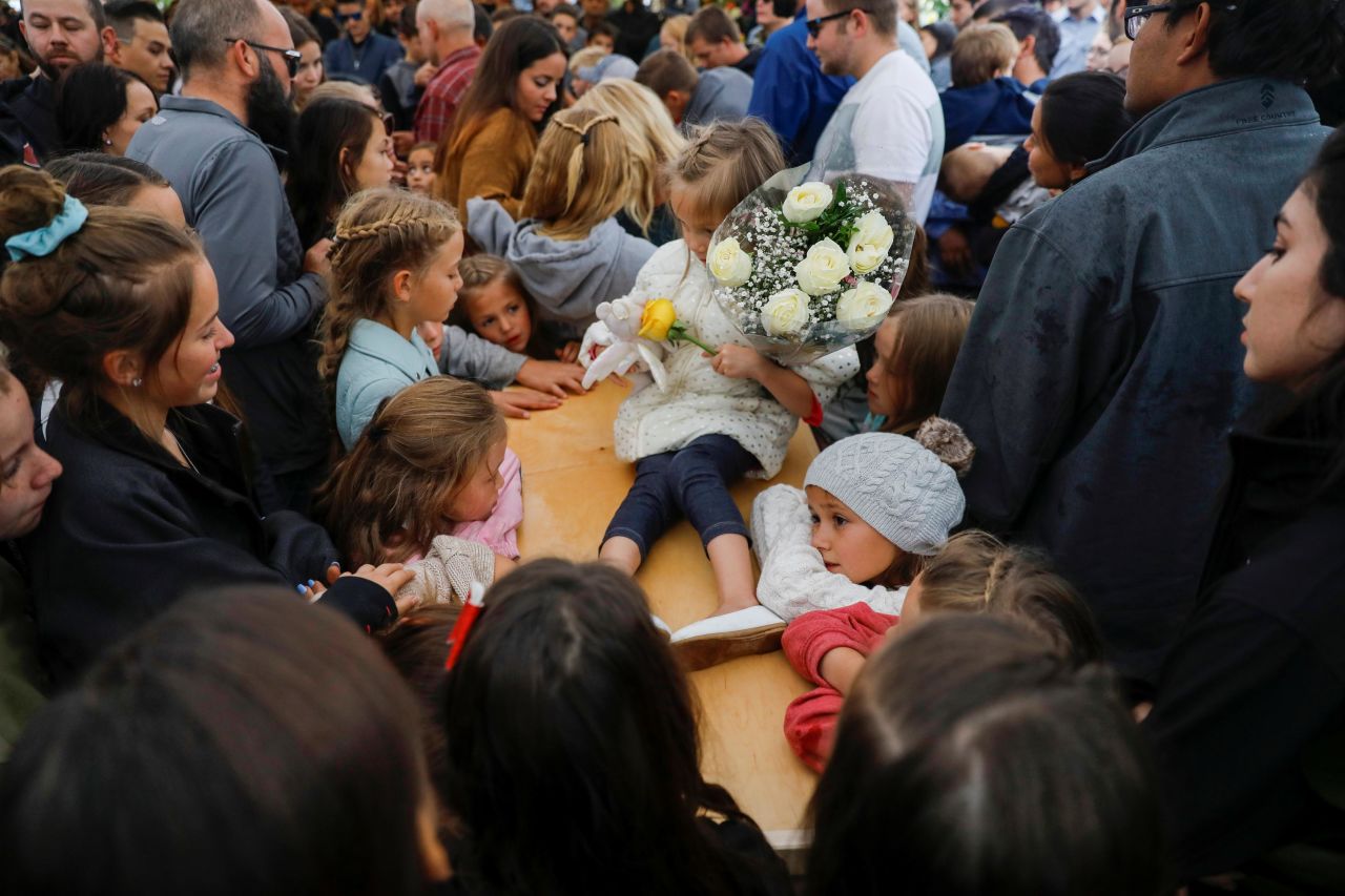 A child sits on top of one of the coffins before the burial.