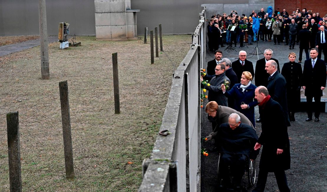 German Chancellor Angela Merkel and others place flowers at the Wall Memorial.