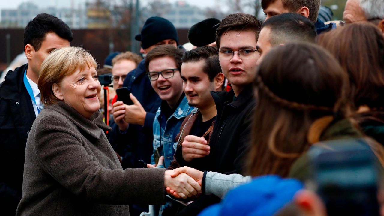 German Chancellor Angela Merkel greets young visitors as she walks to the Chapel of Reconciliation before attending the memorial service.