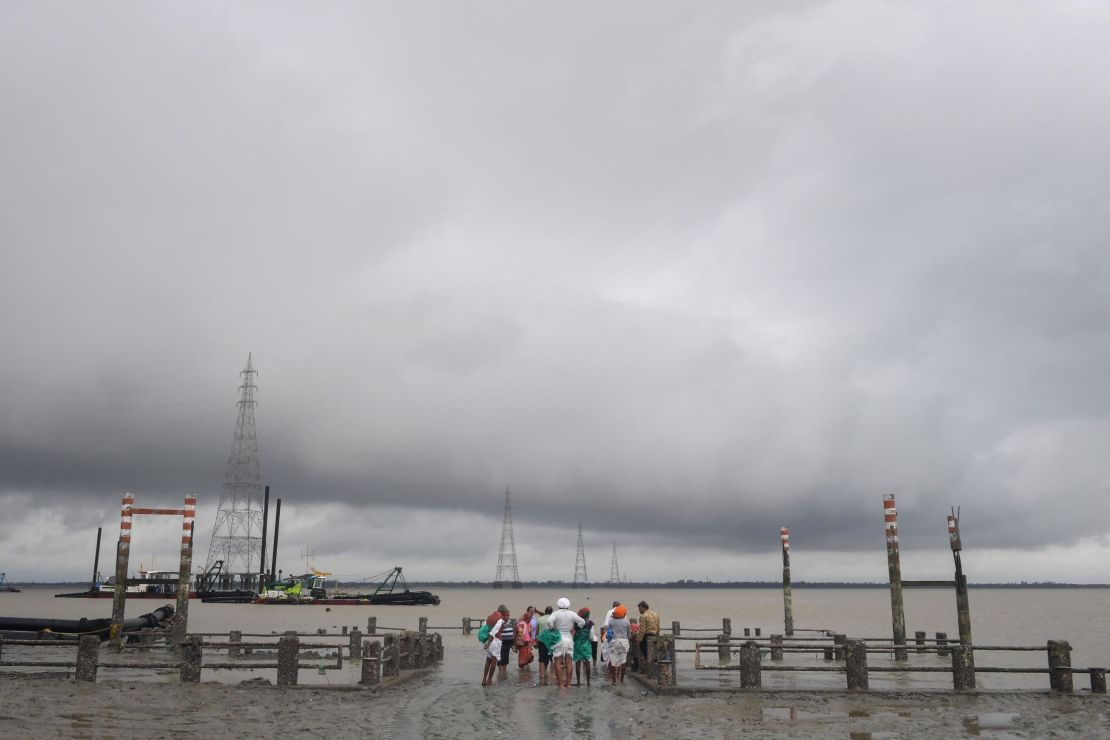 Hindu pilgrims stand by a dock after a ferry service to Sagar Island was suspended due to the approaching Cyclone Bulbul in Kakdwip.