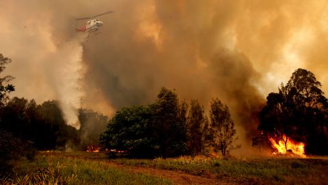 A helicopter drops water on a bushfire in Old Bar on November 9.
