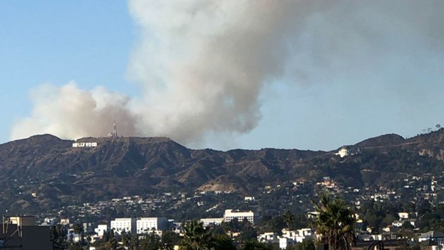 The Barham Fire sends smoke aloft from just behind the Hollywood sign in Los Angeles, California.