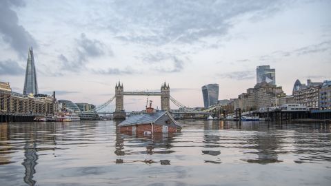 Extinction Rebellion activists floated a submerged replica of a suburban house down the River Thames in protest over rising sea levels. 