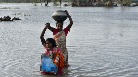 Women carry their belongings from a house submerged in water in the aftermath of Cyclone Bulbul, at Amarabati village in Bakkhali, South 24 Parganas district of India's West Bengal state on November 10, 2019.