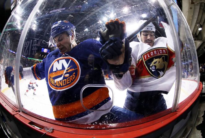 Adam Pelech #3 of the New York Islanders and Brian Boyle #9 of the Florida Panthers crash the boards during their game at Barclays Center on November 9 in New York City.