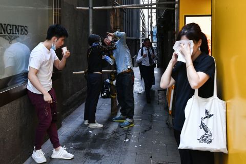 People react after tear gas was fired by police during a protest in Hong Kong's Central District on November 11.