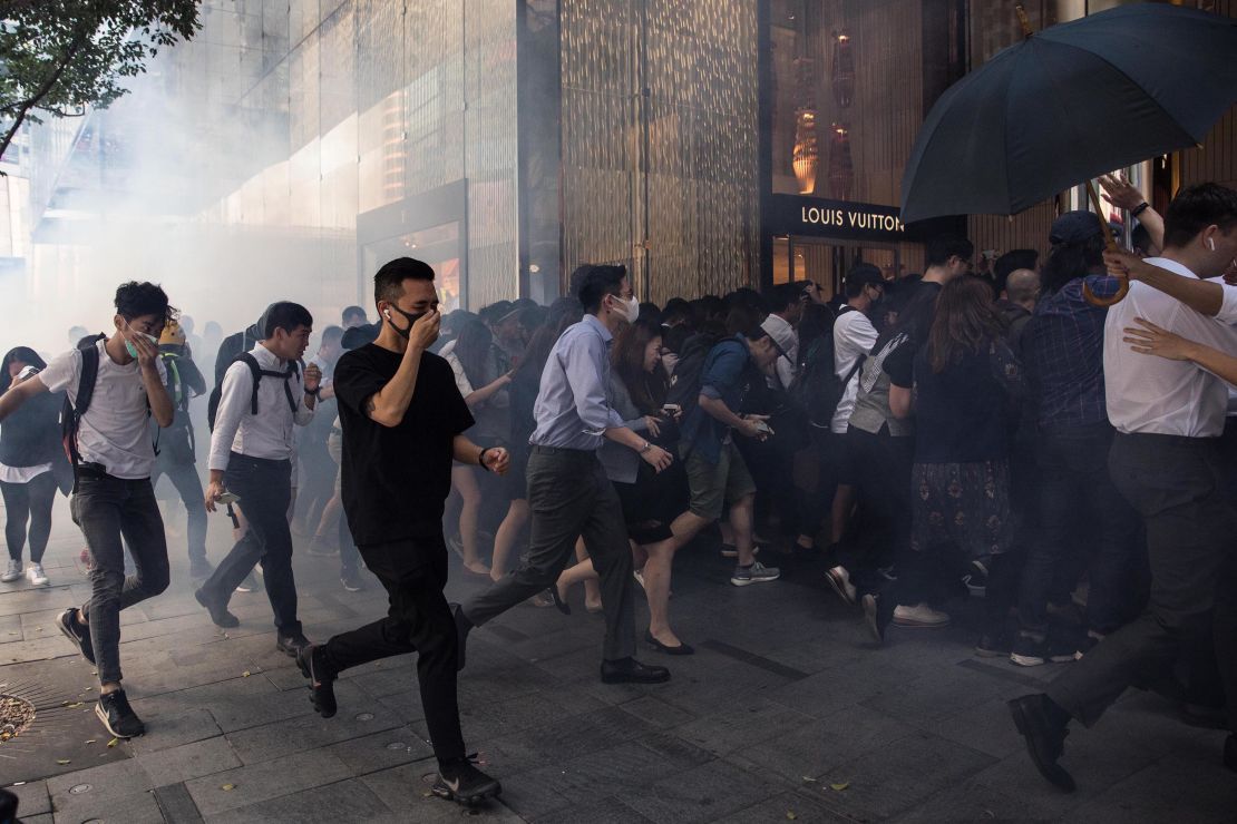 People run into a mall after police fired tear gas in the Central district of Hong Kong on November 11. 