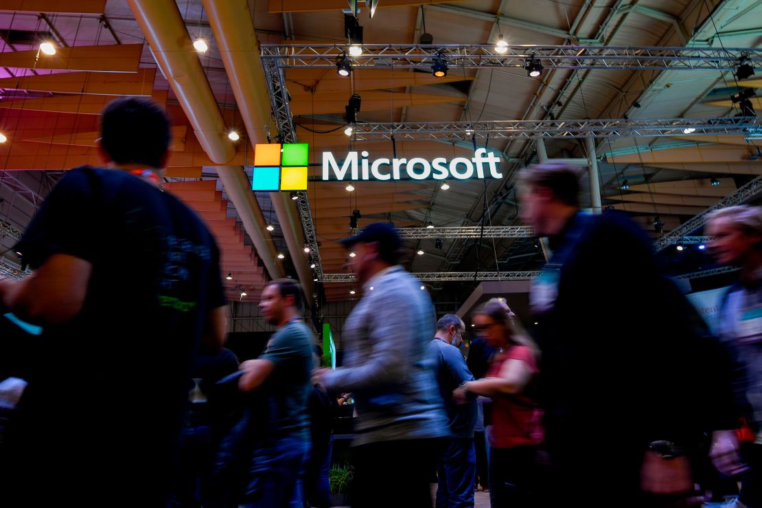 Attendees walk past Microsoft's logo during the Web Summit in Lisbon on November 6, 2019.