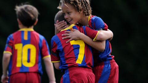 An eight-year-old Xavi Simons (right) celebrates a goal with a teammate during a 2011 match for FC Barcelona's youth team. 