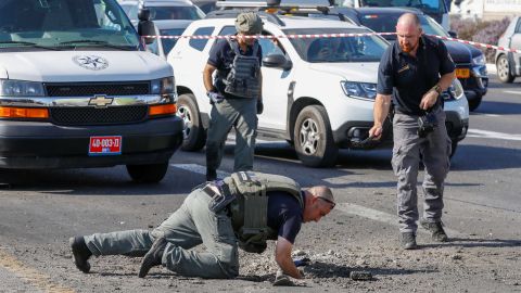 Israeli police inspect a hole in the highway in Ashdod on November 12.