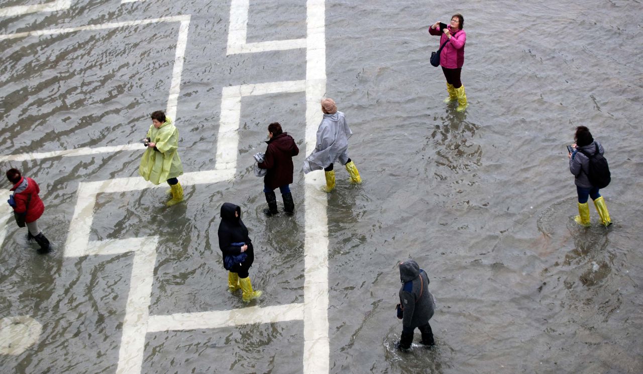 People walk through flood waters in St. Mark's Square on Tuesday.