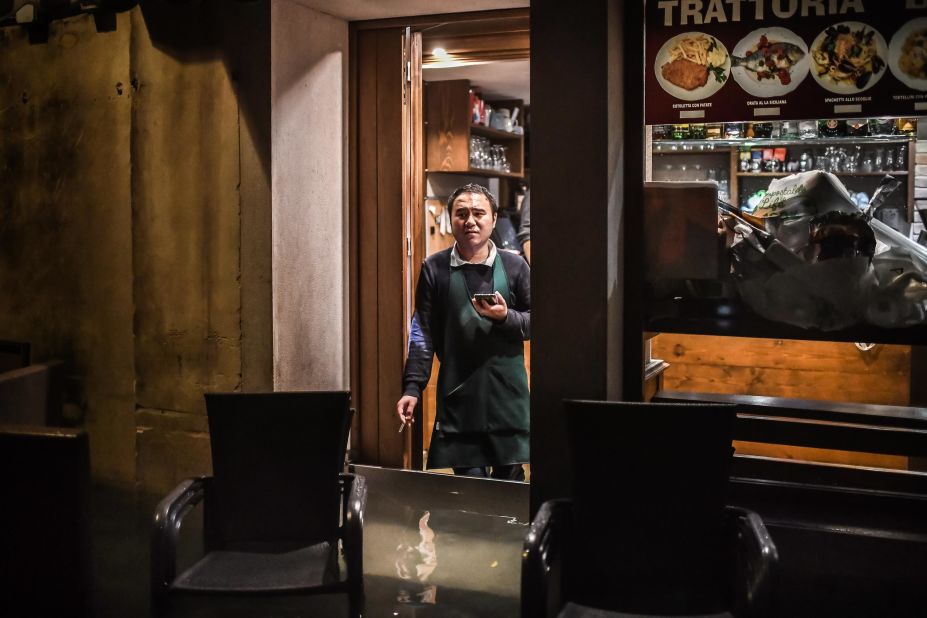 A man stands inside a restaurant barricaded from the flooding on November 12.