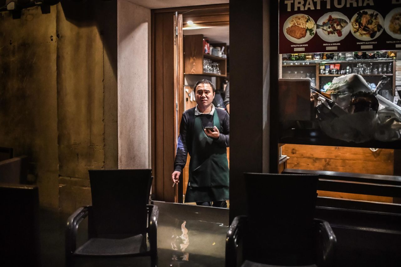 A man stands inside a restaurant barricaded from the flooding on November 12.