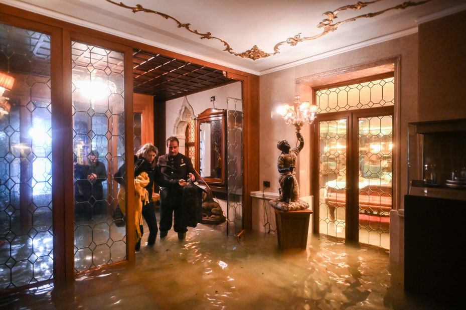 An employee of the Gritti Palace helps a customer navigate a flooded entrance on November 12.