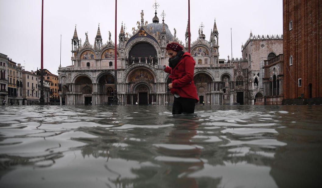 A woman crosses a flooded St. Mark's Square on November 13, after an exceptionally high tide inundated the area overnight. 