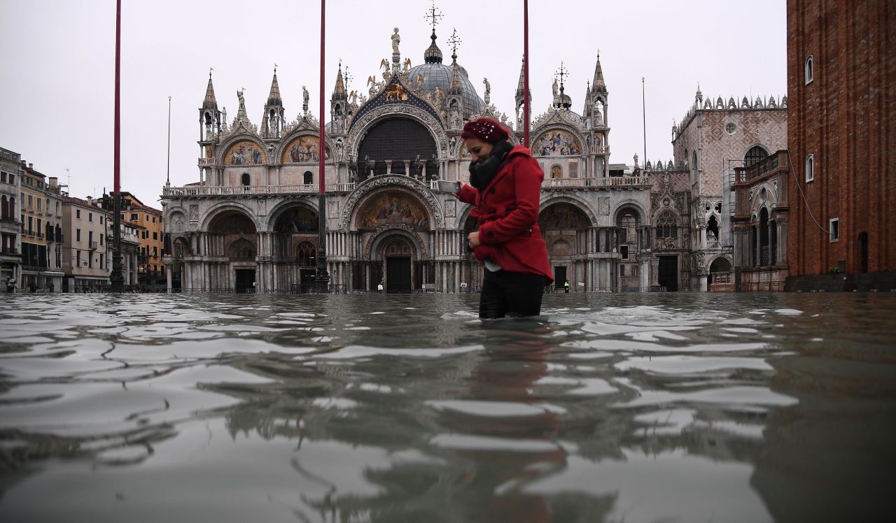 A woman crosses a flooded St. Mark's Square on November 13, after an exceptionally high tide inundated the area overnight.