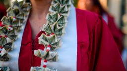 A graduating student wears a money lei, a necklace made of US dollar bills, at the Pasadena City College graduation ceremony, June 14, 2019, in Pasadena, California. - With 45 million borrowers owing $1.5 trillion, the student debt crisis in the United States has exploded in recent years and has become a key electoral issue in the run-up to the 2020 presidential elections.
"Somebody who graduates from a public university this year is expected to have over $35,000 in student loan debt on average," said Cody Hounanian, program director of Student Debt Crisis, a California NGO that assists students and is fighting for reforms.  (Photo credit should read ROBYN BECK/AFP/Getty Images)