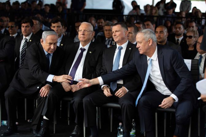 Netanyahu and Israeli Blue and White party chief Benny Gantz reach to shake hands during a state memorial ceremony for former Israeli Prime Minister Yitzhak Rabin and his wife Leah in Jerusalem on November 10. Exit polls for a <a href="index.php?page=&url=https%3A%2F%2Fedition.cnn.com%2F2019%2F09%2F18%2Fmiddleeast%2Fisrael-elections-gantz-netanyahu-results-intl%2Findex.html" target="_blank">repeat general election in September</a> failed to give either of the political rivals a majority in the new parliament.