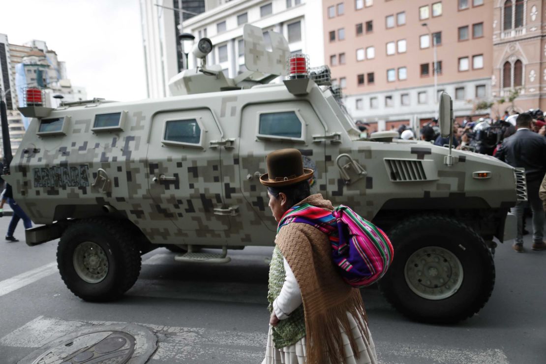 A military armored vehicle patrols as supporters of former President Morales march in La Paz.