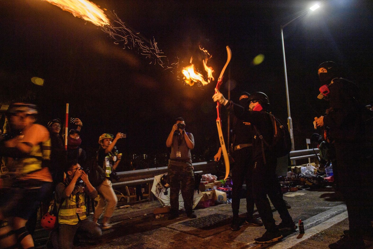 A protester releases a flaming arrow to light a barricade at The Chinese University of Hong Kong (CUHK), Wednesday, November 13.