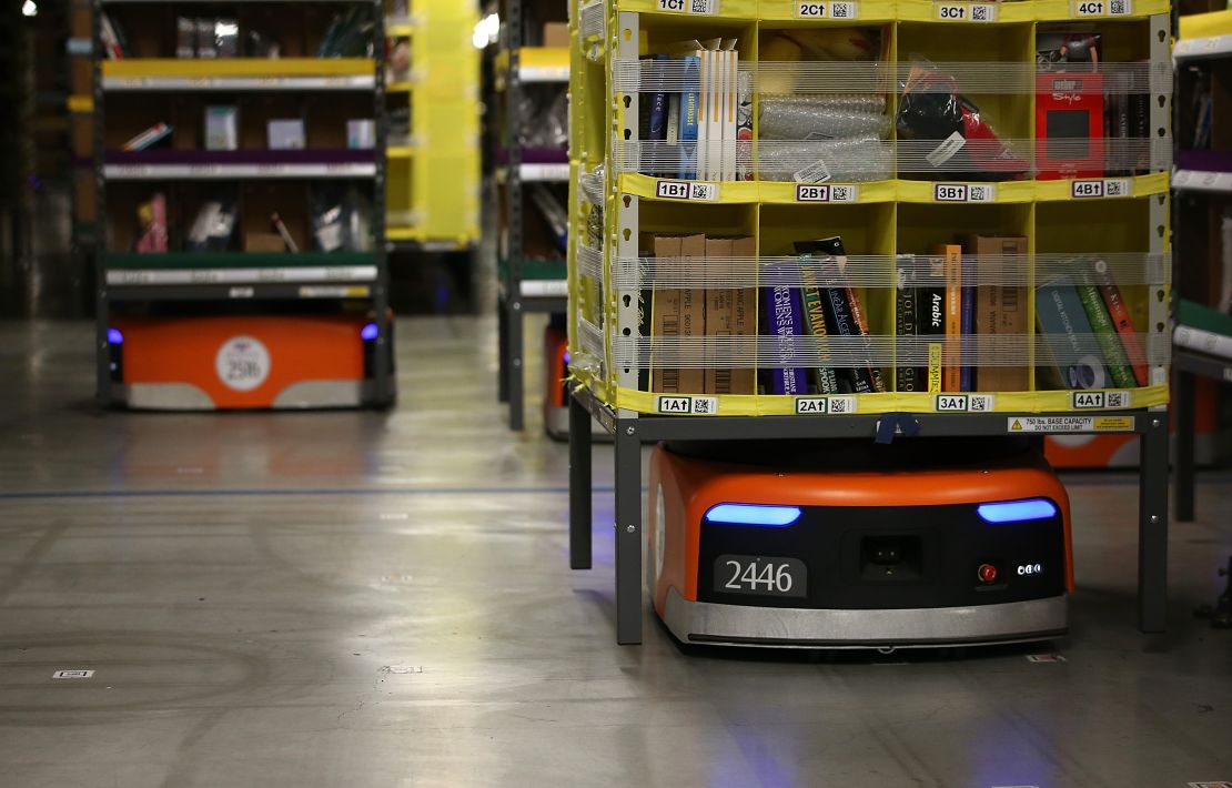 Robots move shelves of merchandise at an Amazon fulfillment center.