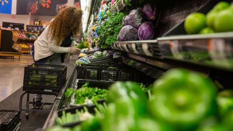 An employees stocks the produce section on the eve of the store reopening.
