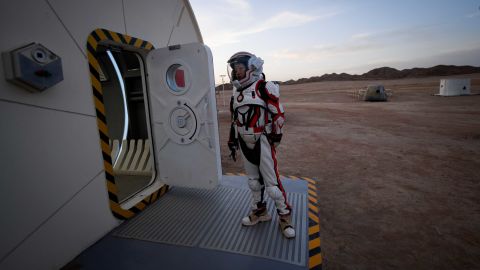 This picture taken on April 17, 2019 shows a woman wearing a spacesuit walking out of "Mars Base 1", a C-Space Project, in the Gobi desert, some 40 kilometres from Jinchang in China's northwest Gansu province.  Surrounded by barren hills in northwest Gansu province, "Mars Base 1" opened to the public on April 17 with the aim of exposing teens -- and soon tourists -- to what life could be like on the planet. 