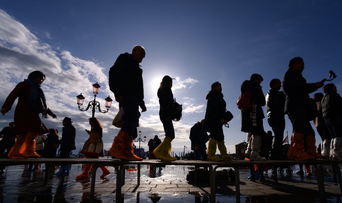 People walk across a footbridge on Riva degli Schiavoni on November 14, 2019 in Venice.