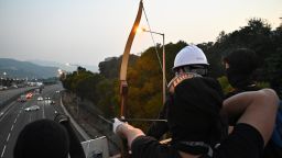 A protester uses an arrow to guide cars on the Tolo Highway outside the Chinese University of Hong Kong (CUHK), in Hong Kong on November 13, 2019. - Pro-democracy protesters stepped up on November 13 a "blossom everywhere" campaign of road blocks and vandalism across Hong Kong that has crippled the international financial hub this week and ignited some of the worst violence in five months of unrest. (Photo by Philip FONG / AFP) (Photo by PHILIP FONG/AFP via Getty Images)