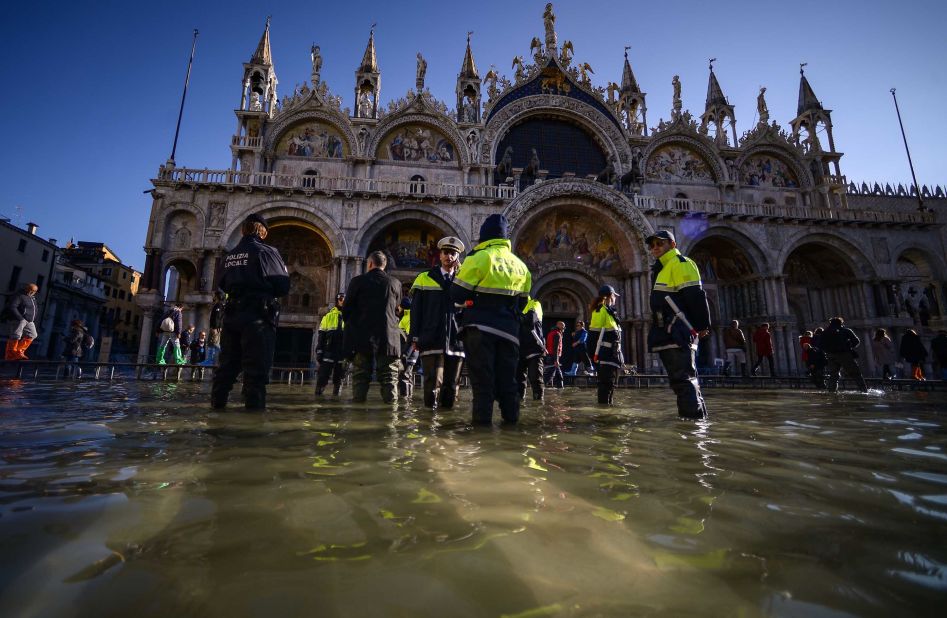 Members of the municipal police stand in water by St. Mark's Basilica on November 14.