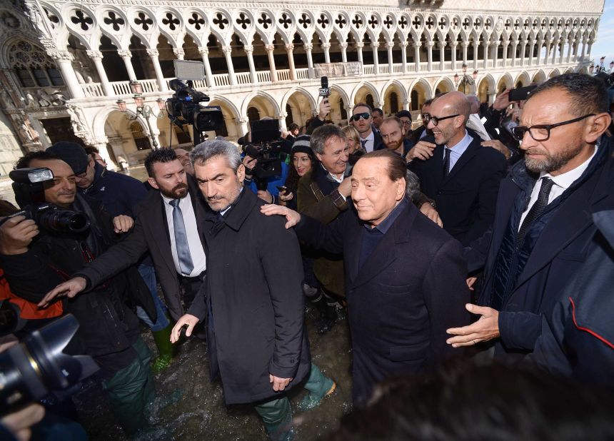 Head of the Forza Italia party and former Italian Prime Minister Silvio Berlusconi, second from right, assesses the flood damage on November 14.